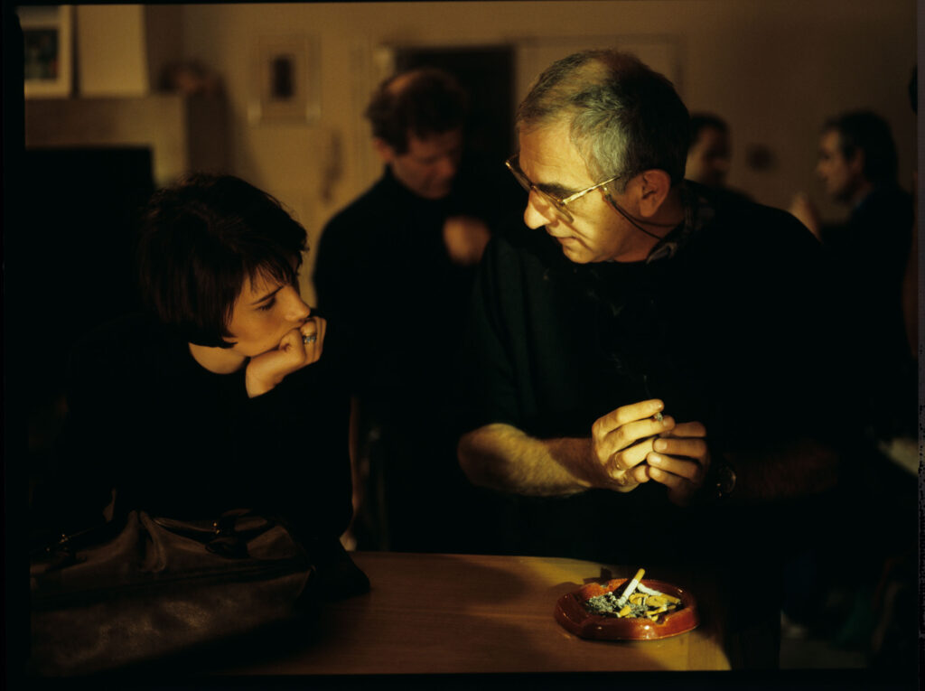 Krzysztof Kieślowski (reżyser) rozmawia z aktorką Juliette Binoche na planie zdjęciowym. W tle tłumacz Roman Gren.