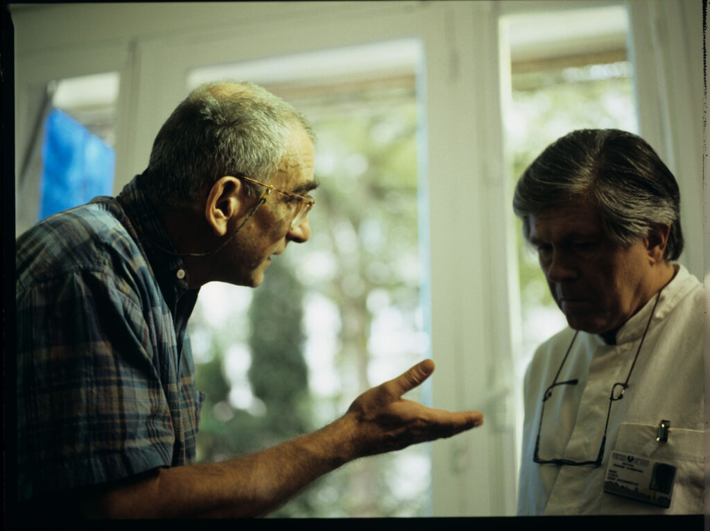 Kieślowski (reżyser) udziela wskazówek odtwórcy roli lekarza Claude Dunetonowi na planie zdjęciowym w szpitalu.