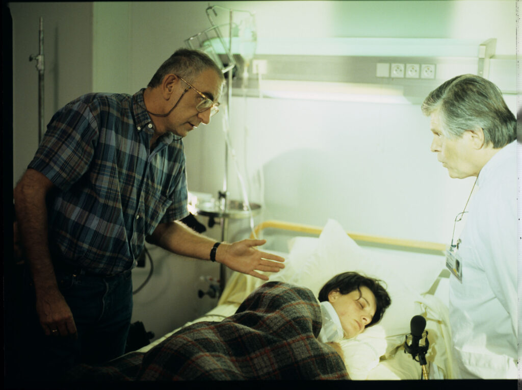 Krzysztof Kieślowski (reżyser), na planie zdjęciowym w szpitalu, udziela wskazówek aktorom.