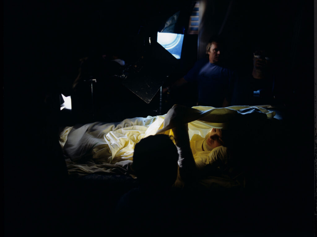 The set in the hospital room, where Julie watches the coverage of the funeral of her husband and daughter on a portable TV.