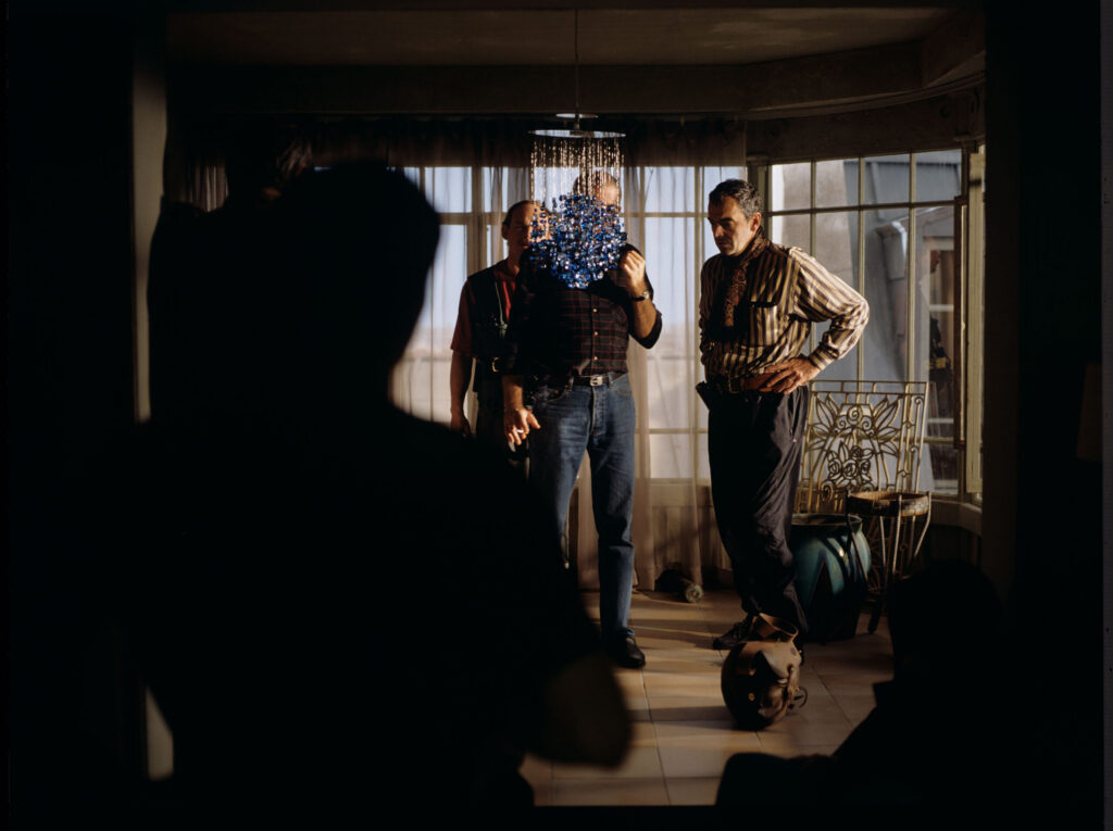 The set in Julie's Parisian apartment. The team's attention is focused on an important prop - a blue chandelier.