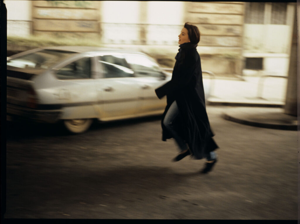 Julie (Juliette Binoche) running after the car of Olivier, a co-worker of her tragically deceased husband.
