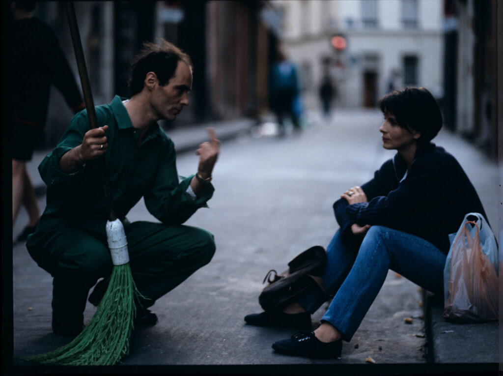 Julie (Juliette Binoche) is sitting on the sidewalk and talking to a street cleaner. The scene did not appear in the film.