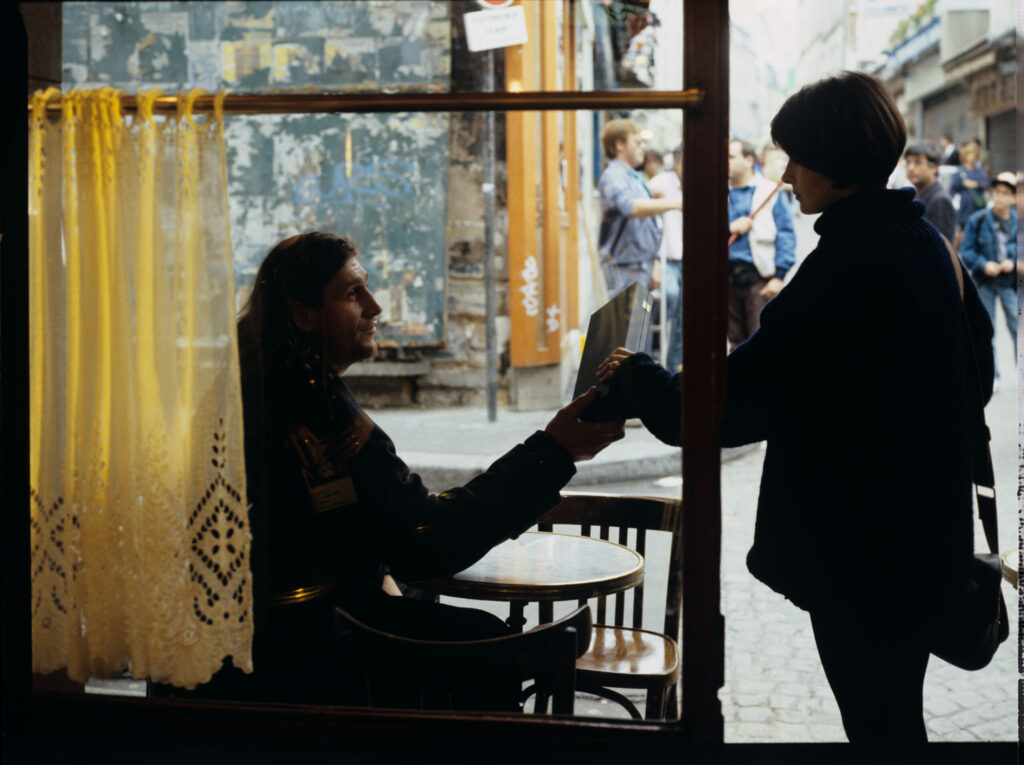 Julie (Juliette Binoche) in front of a café on a Parisian street. The scene did not appear in the film.