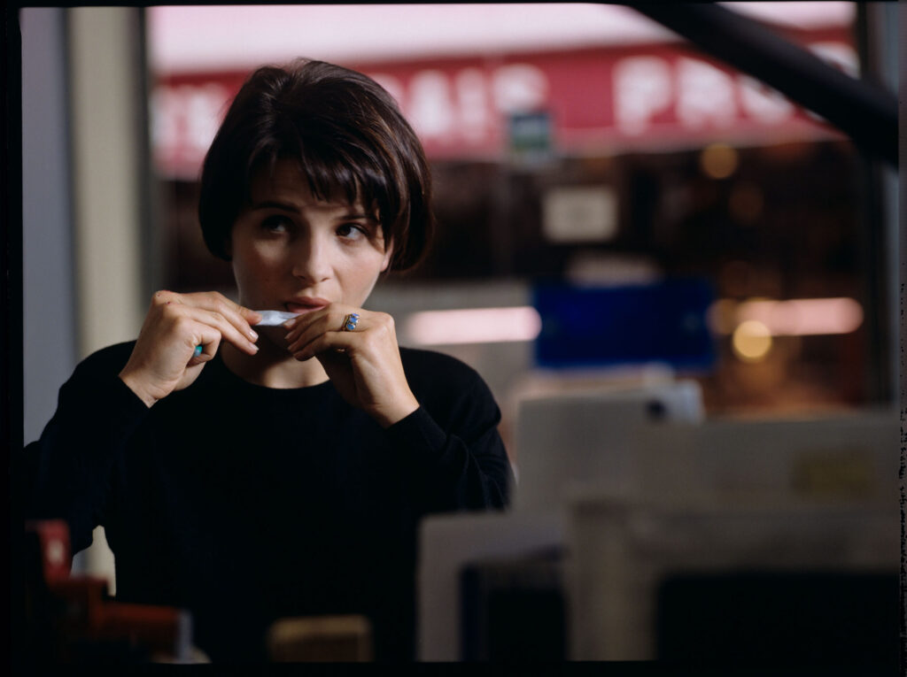 Julie (Juliette Binoche) sitting in a cafe on the street where she lives.