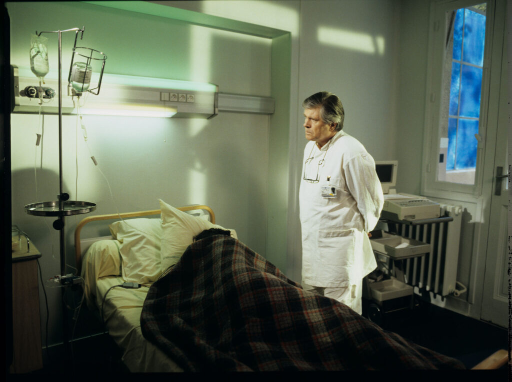 Doctor (Claude Duneton) informs Julie (Juliette Binoche) about the death of her husband and daughter