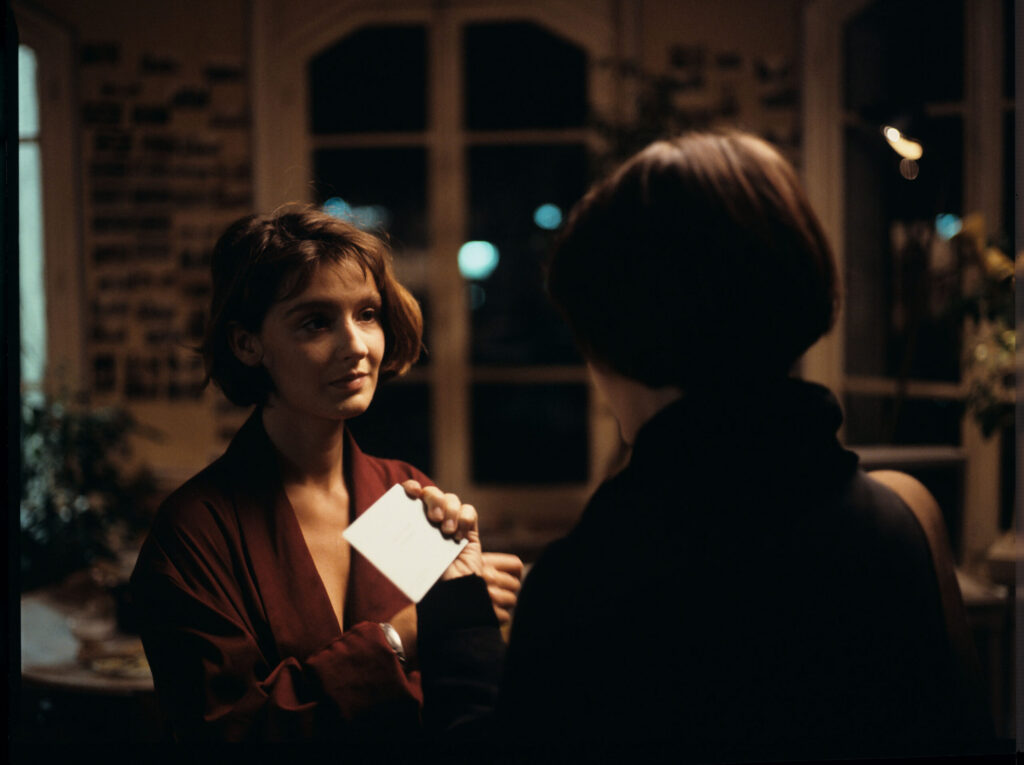 The copyist (Florence Vignon) gives Julie (Juliette Binoche) a business card with Oliver's address and telephone number.