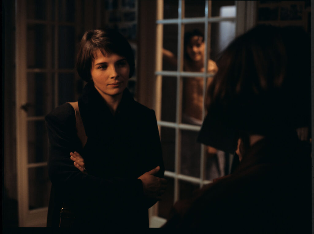 Julie (Juliette Binoche) przybywa do kopistki (Florence Vignon), aby uzyskać od niej numer telefonu i adres Oliviera.