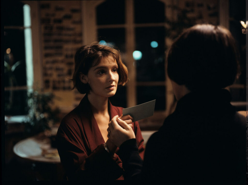 The copyist (Florence Vignon) gives Julie (Juliette Binoche) a business card with Oliver's address and telephone number.