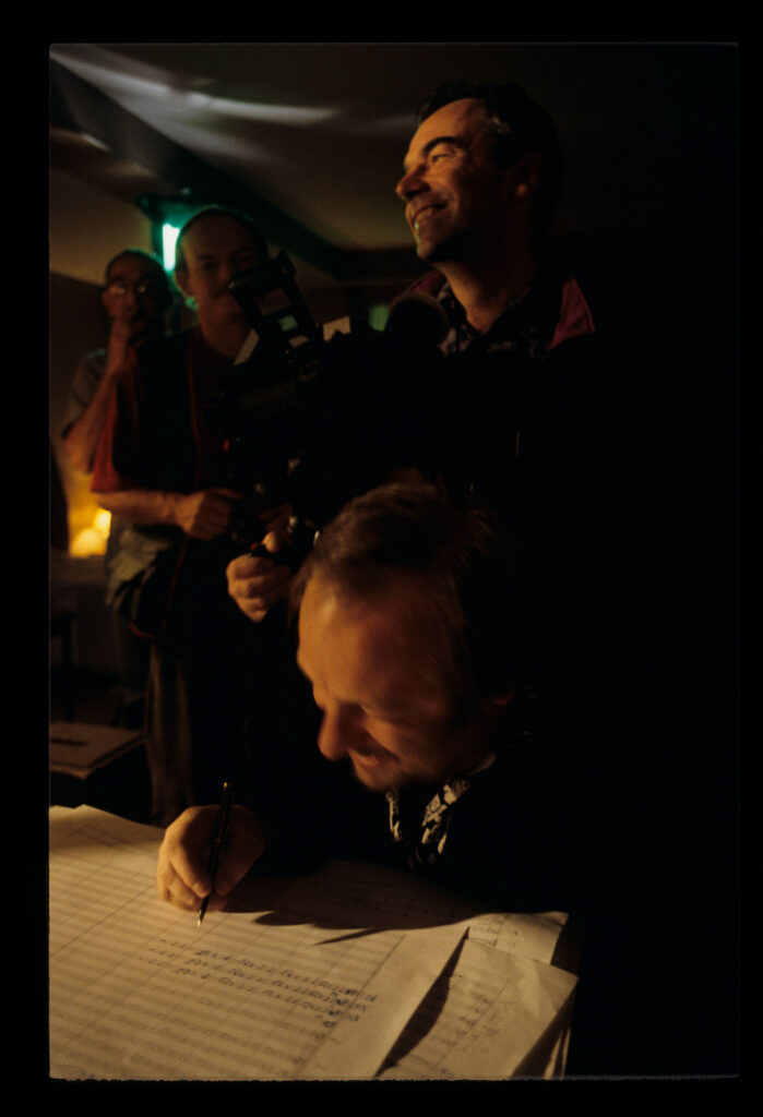 Zbigniew Preisner (kompozytor muzyki do filmu) nad zapisem nutowym. Na zdjęciu członkowie ekipy filmowej.