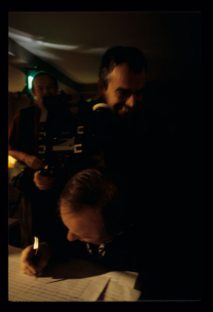 Zbigniew Preisner (kompozytor muzyki do filmu) nad zapisem nutowym. Na zdjęciu członkowie ekipy filmowej.