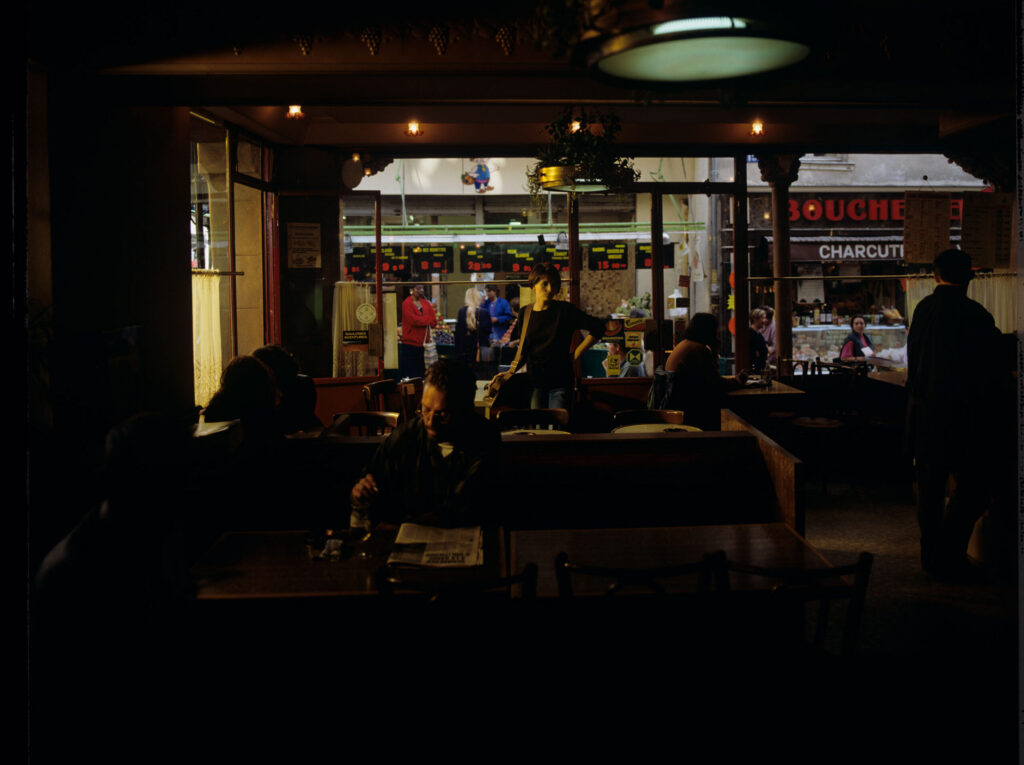 Julie (Juliette Binoche) in the café where she has been visiting every day since she moved to Paris.