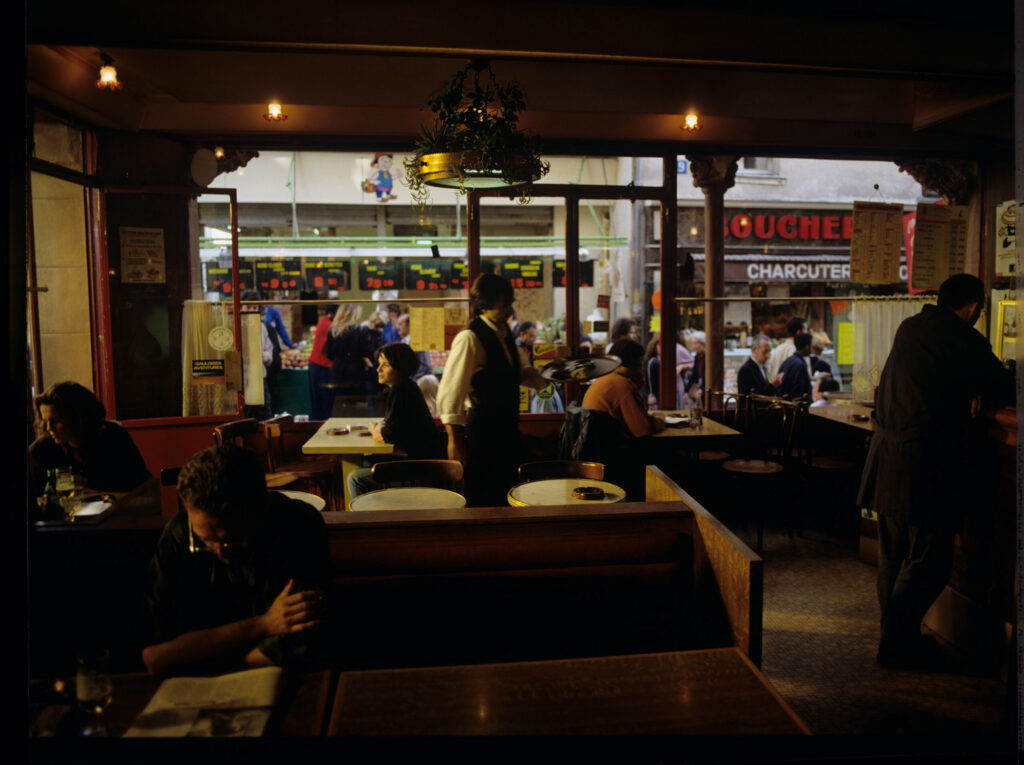 Julie (Juliette Binoche) in the café where she has been visiting every day since she moved to Paris.