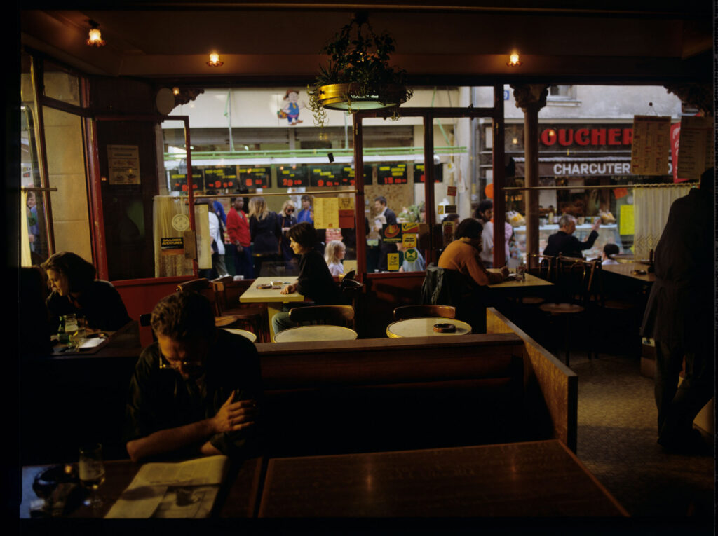 Julie (Juliette Binoche) in the café where she has been visiting every day since she moved to Paris.