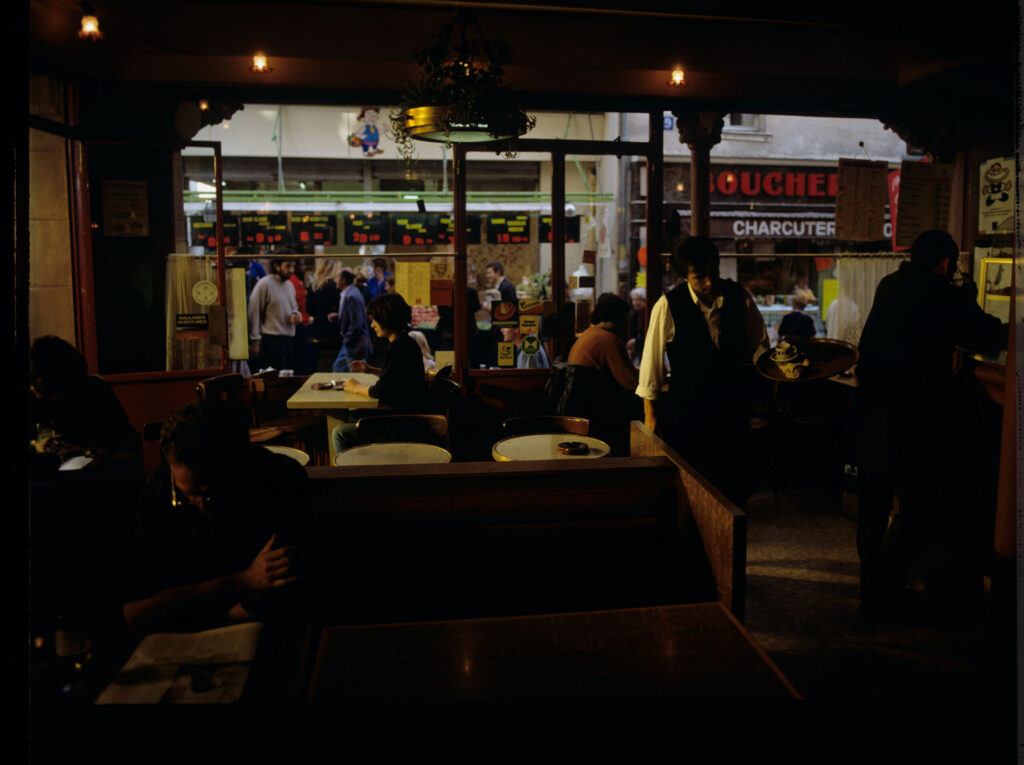 Julie (Juliette Binoche) in the café where she has been visiting every day since she moved to Paris.