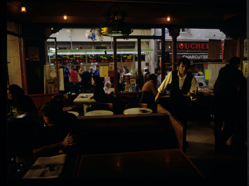 Julie (Juliette Binoche) in the café where she has been visiting every day since she moved to Paris.