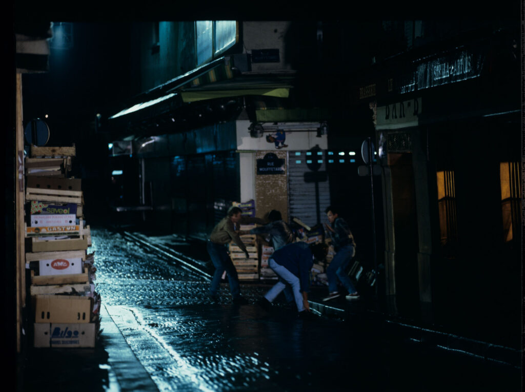 A scene of a street fight which the terrified Julie observes through the window of her apartment.