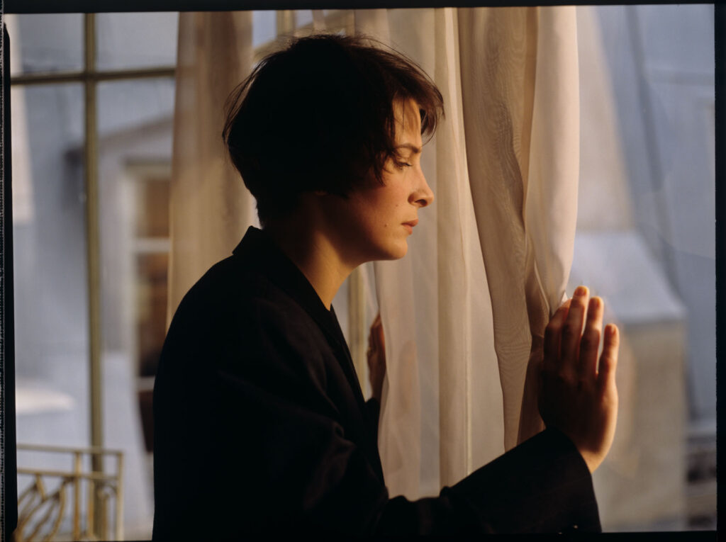 Fotos presenting the main character Julie (Juliette Binoche) by the window in her apartment in Paris