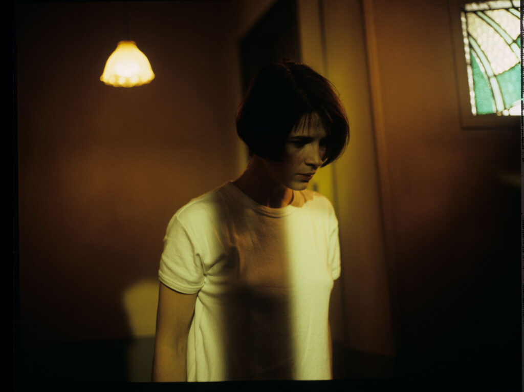 Concerned by noises, Julie (Juliette Binoche) leaves the apartment and accidentally slams the door behind her.
