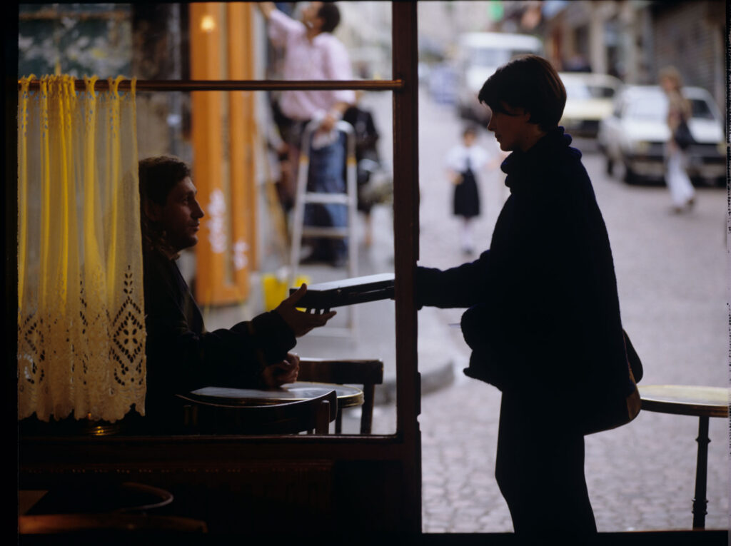 Julie (Juliette Binoche) takes a flute from a man belonging to a street flutist.