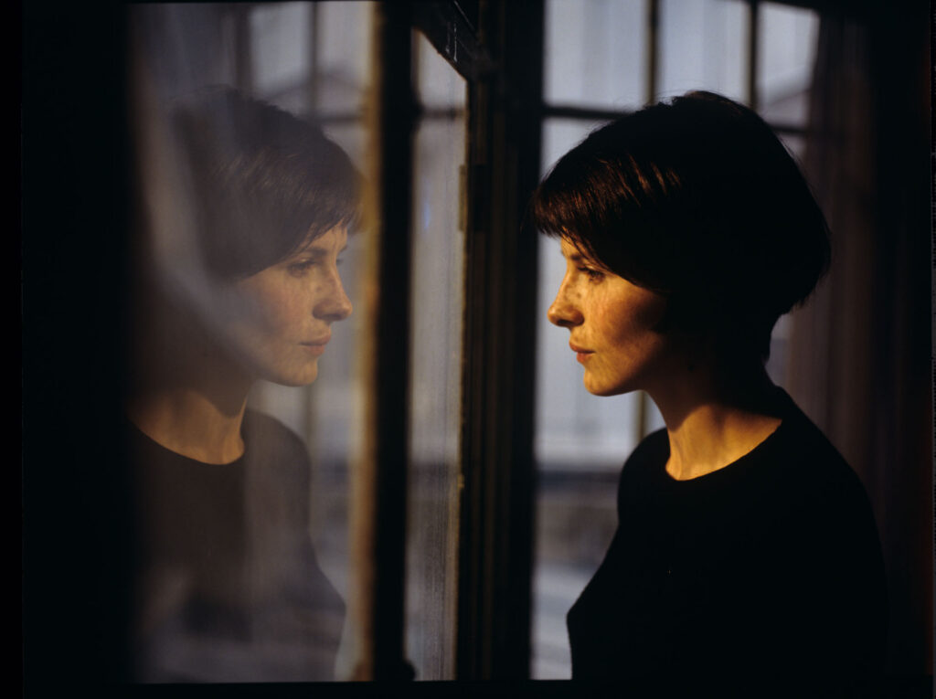 Julie (Juliette Binoche) watches a raindrop drip down the window.