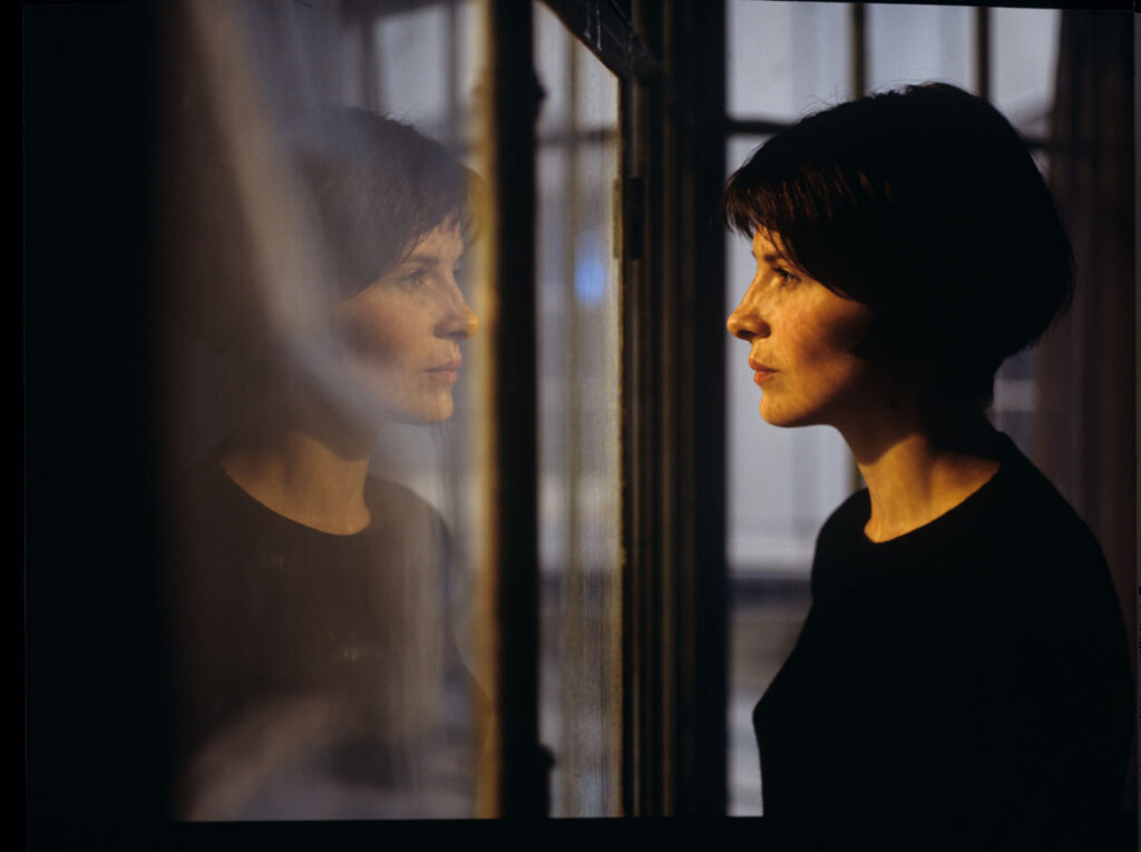 Julie (Juliette Binoche) watches a raindrop drip down the window.