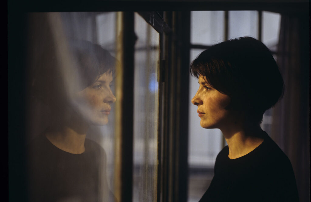 Julie (Juliette Binoche) watches a raindrop drip down the window.