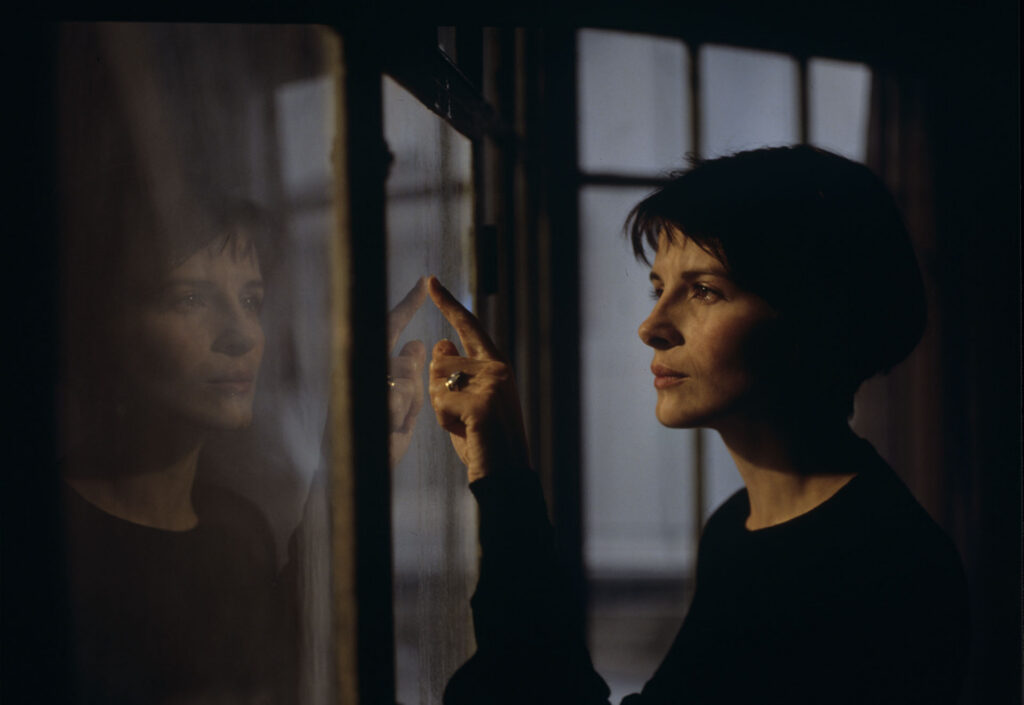 Julie (Juliette Binoche) watches a raindrop drip down the window.