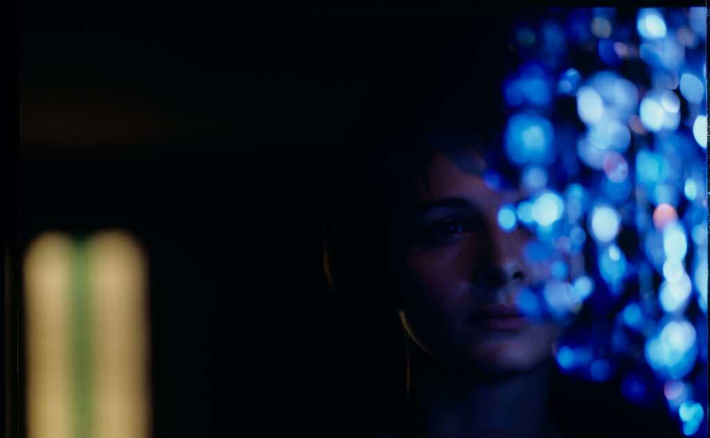 Fotos presenting the main character Julie (Juliette Binoche) looking at the blue chandellier.