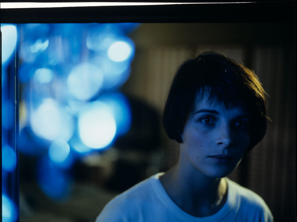 Fotos presenting the main character Julie (Juliette Binoche) with the blue chandellier in the background.