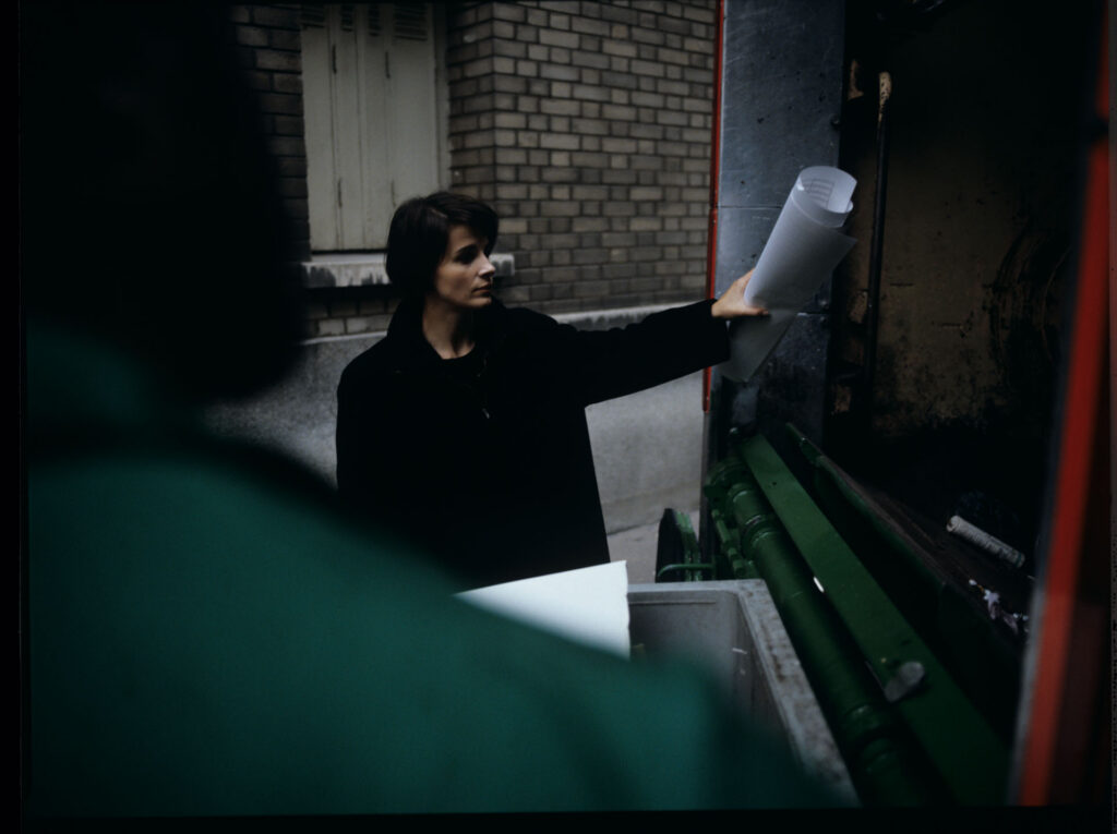 Julie (Juliette Binoche) throws sheet music into the garbage truck with an unfinished composition of her deceased husband.