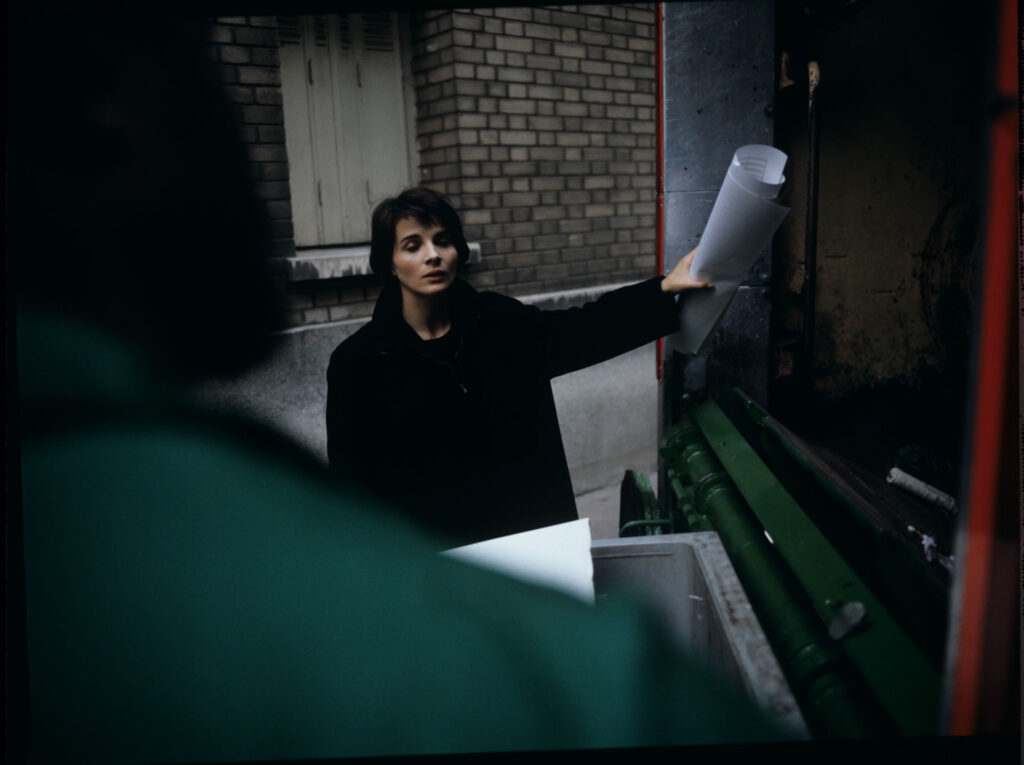Julie (Juliette Binoche) throws sheet music into the garbage truck with an unfinished composition of her deceased husband.