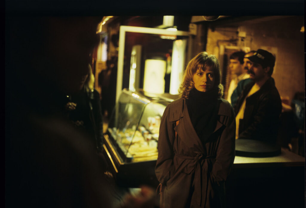 Lucille (Charlotte Very), Julie's neighbor who works at a nightclub, on a Parisian street.
