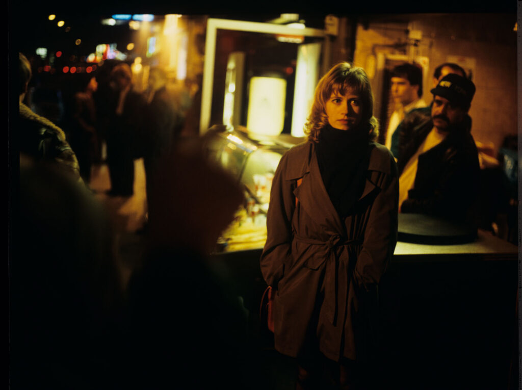 Lucille (Charlotte Very), Julie's neighbor who works at a nightclub, on a Parisian street.