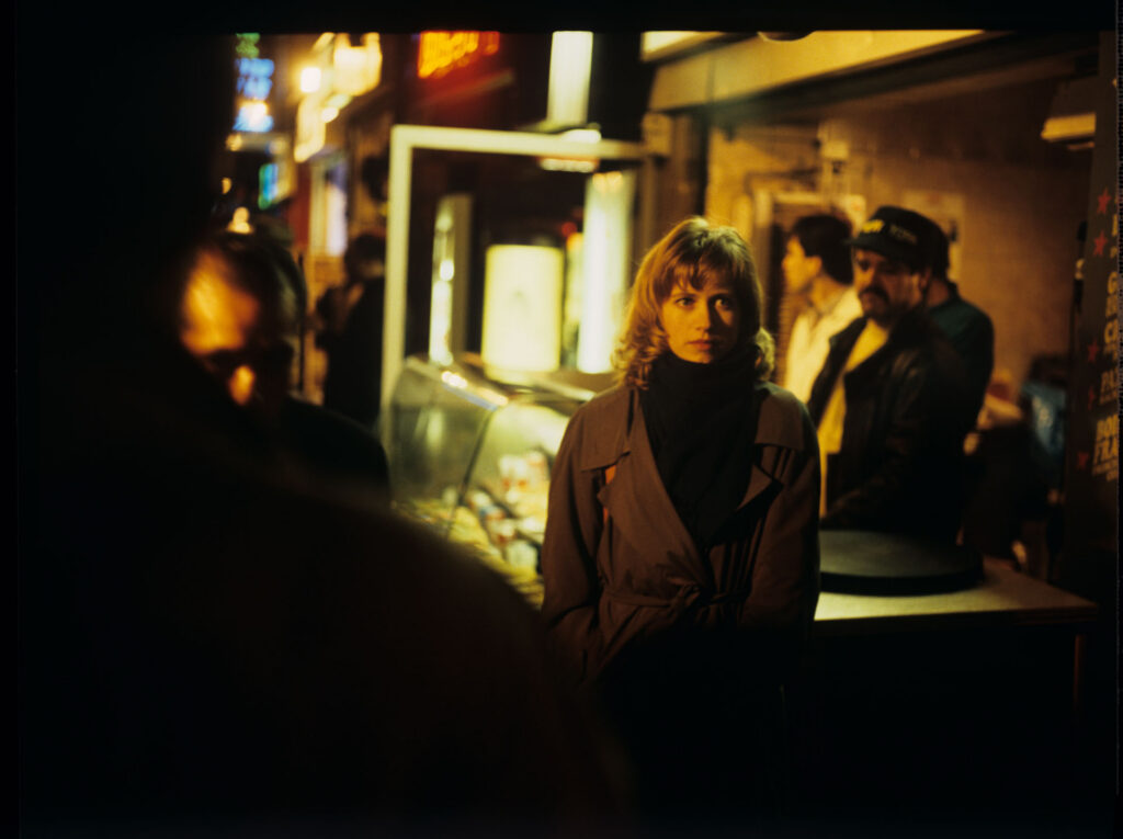 Lucille (Charlotte Very), Julie's neighbor who works at a nightclub, on a Parisian street.