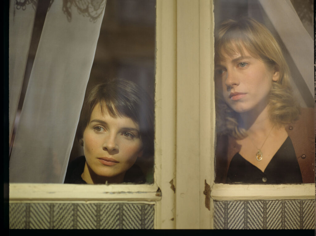Julie (Juliette Binoche) and Lucille (Charlotte Very) looking through the window
