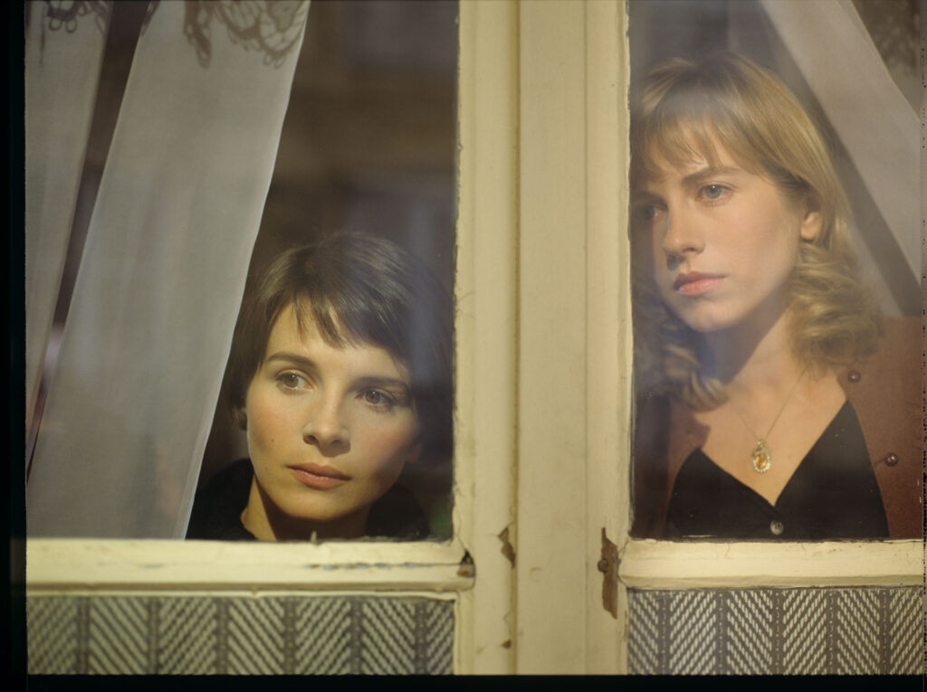 Julie (Juliette Binoche) and Lucille (Charlotte Very) looking through the window