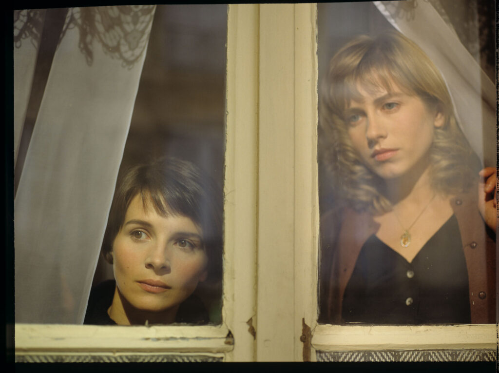 Julie (Juliette Binoche) and Lucille (Charlotte Very) looking through the window