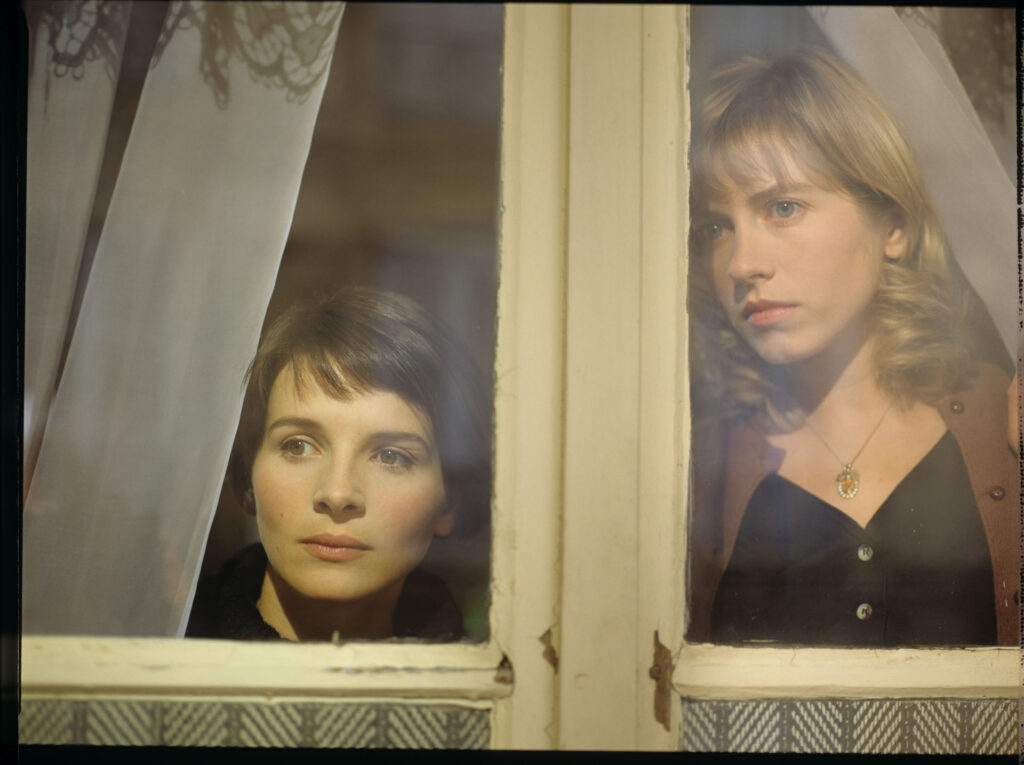 Julie (Juliette Binoche) and Lucille (Charlotte Very) looking through the window