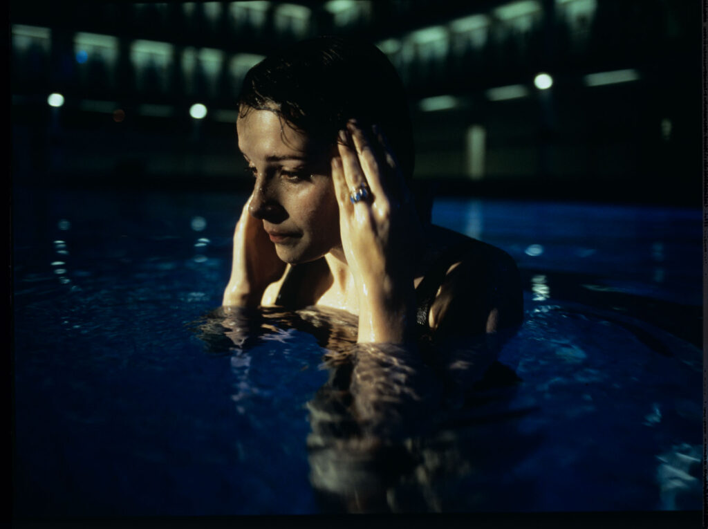 Julie (Juliette Binoche) in a blue glow, where she releases accumulated emotions while swimming.