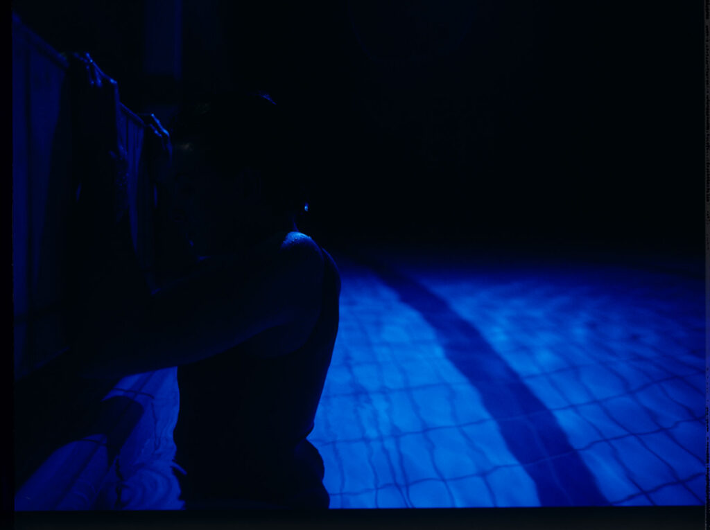 Julie (Juliette Binoche) in a blue glow, where she releases accumulated emotions while swimming.