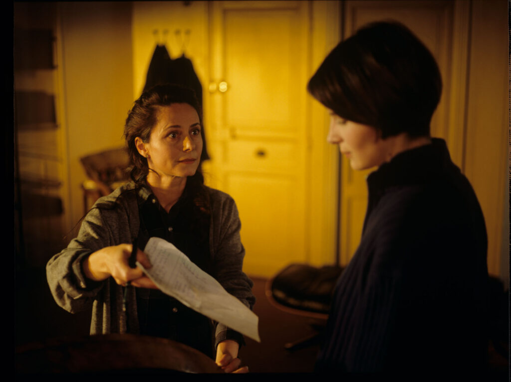Julie (Juliette Binoche) with her neighbor (Catherine Therouenne) collecting signatures for a petition.