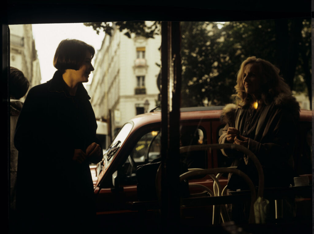 Julie (Juliette Binoche) is talking to a journalist (Helene Vincent) through her car window.