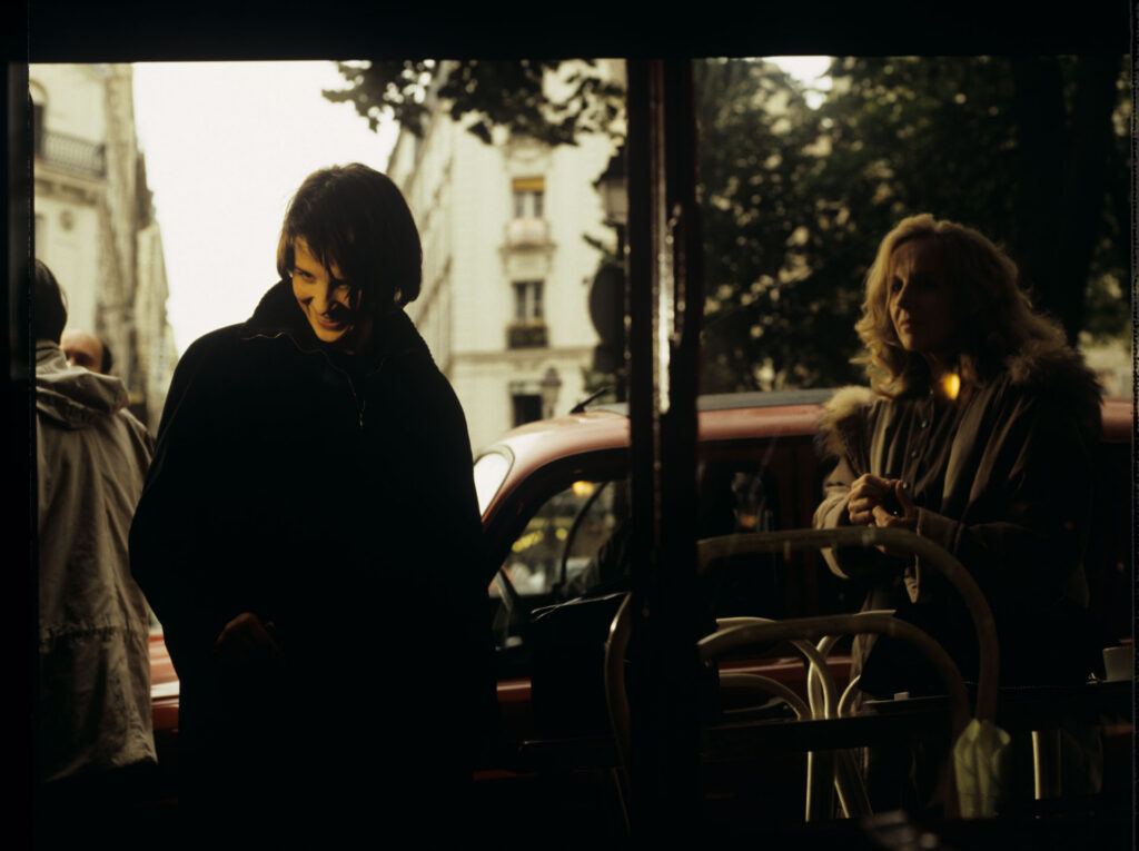 Julie (Juliette Binoche) is talking to a journalist (Helene Vincent) through her car window.