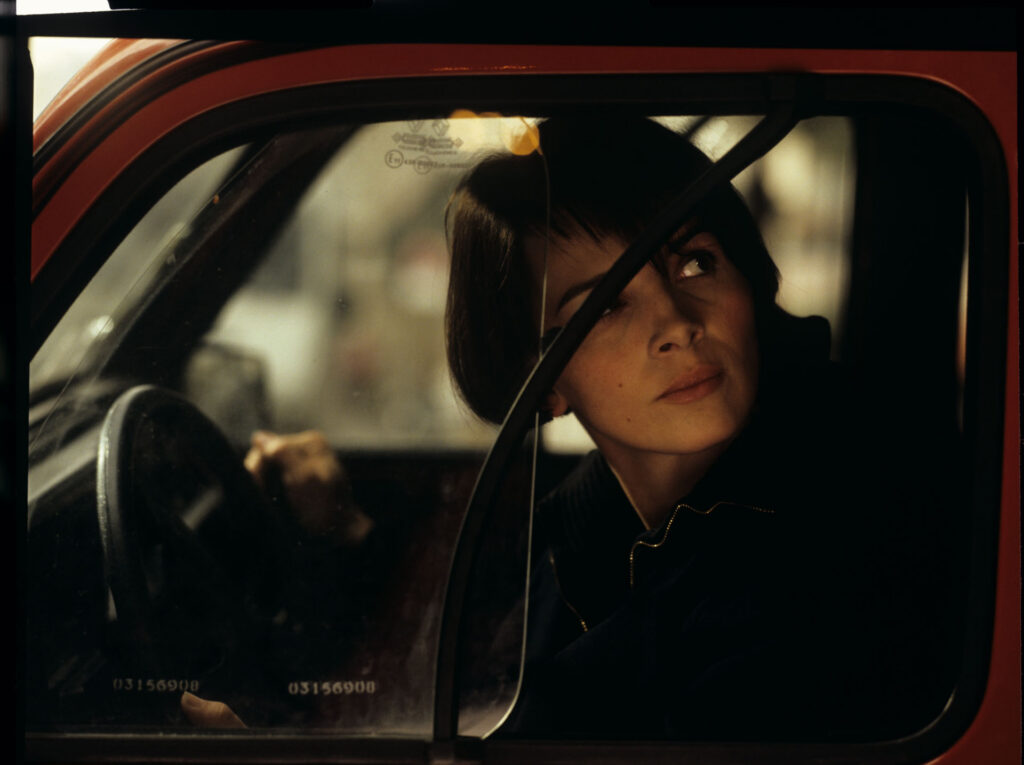 Julie (Juliette Binoche) is talking to a journalist (Helene Vincent) through her car window.