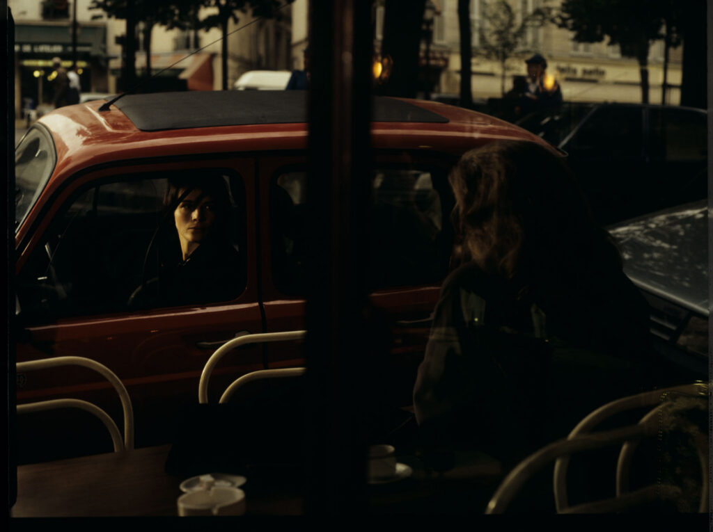 Julie (Juliette Binoche) is talking to a journalist (Helene Vincent) through her car window.