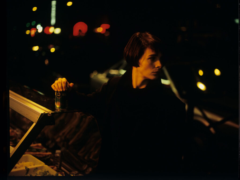 Julie (Juliette Binoche) in a night shot in a Paris street.