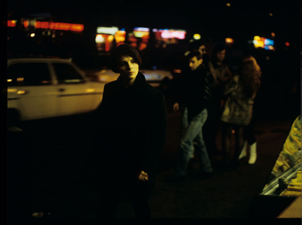 Julie (Juliette Binoche) in a night shot in a Paris street.