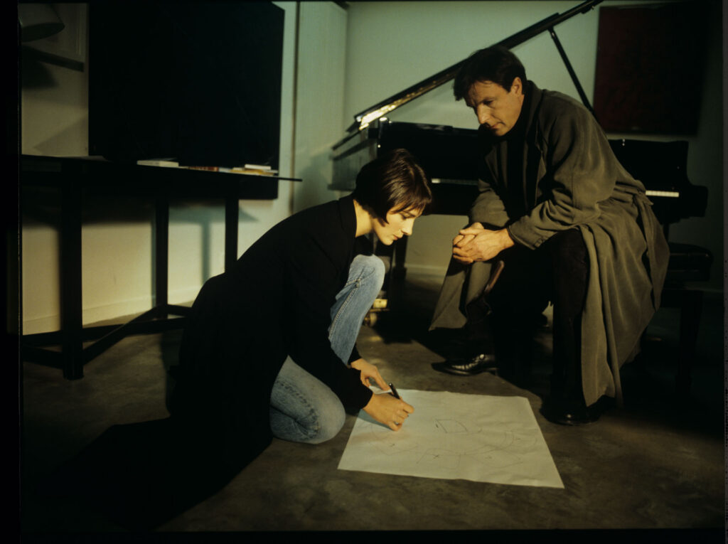 Julie (Juliette Binoche) and Olivier (Benoit Regent) working on finishing Patrice's, Julie's husband, composition.