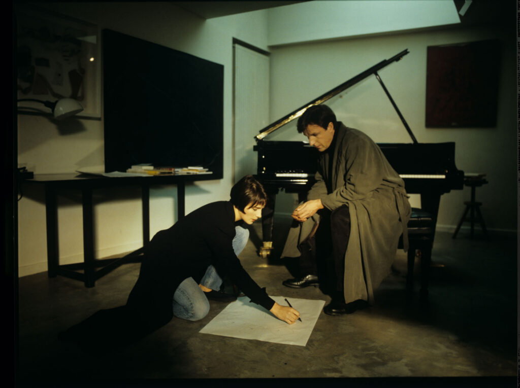 Julie (Juliette Binoche) and Olivier (Benoit Regent) working on finishing Patrice's, Julie's husband, composition.